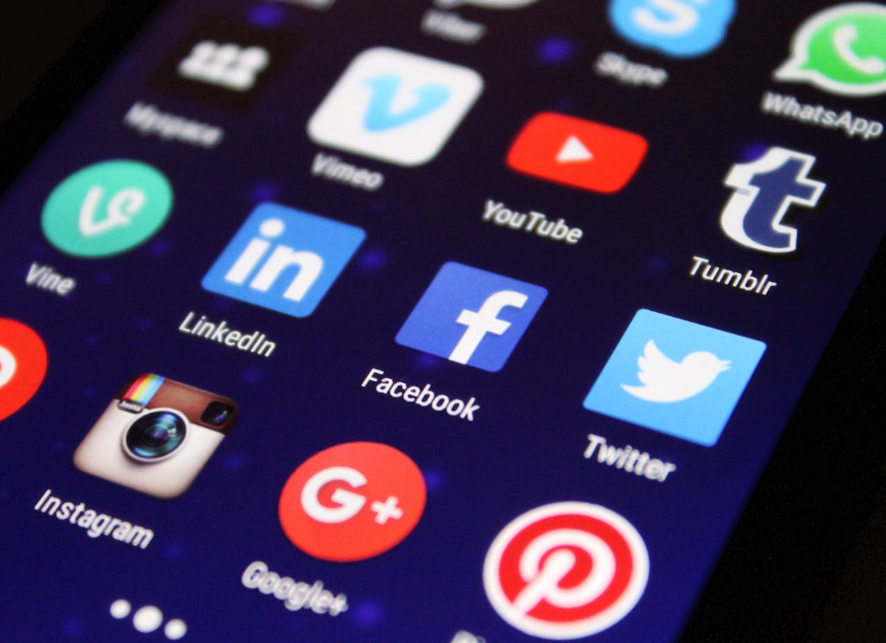 home-img Close-up of a smartphone screen showing various social media app icons such as Facebook and Twitter.