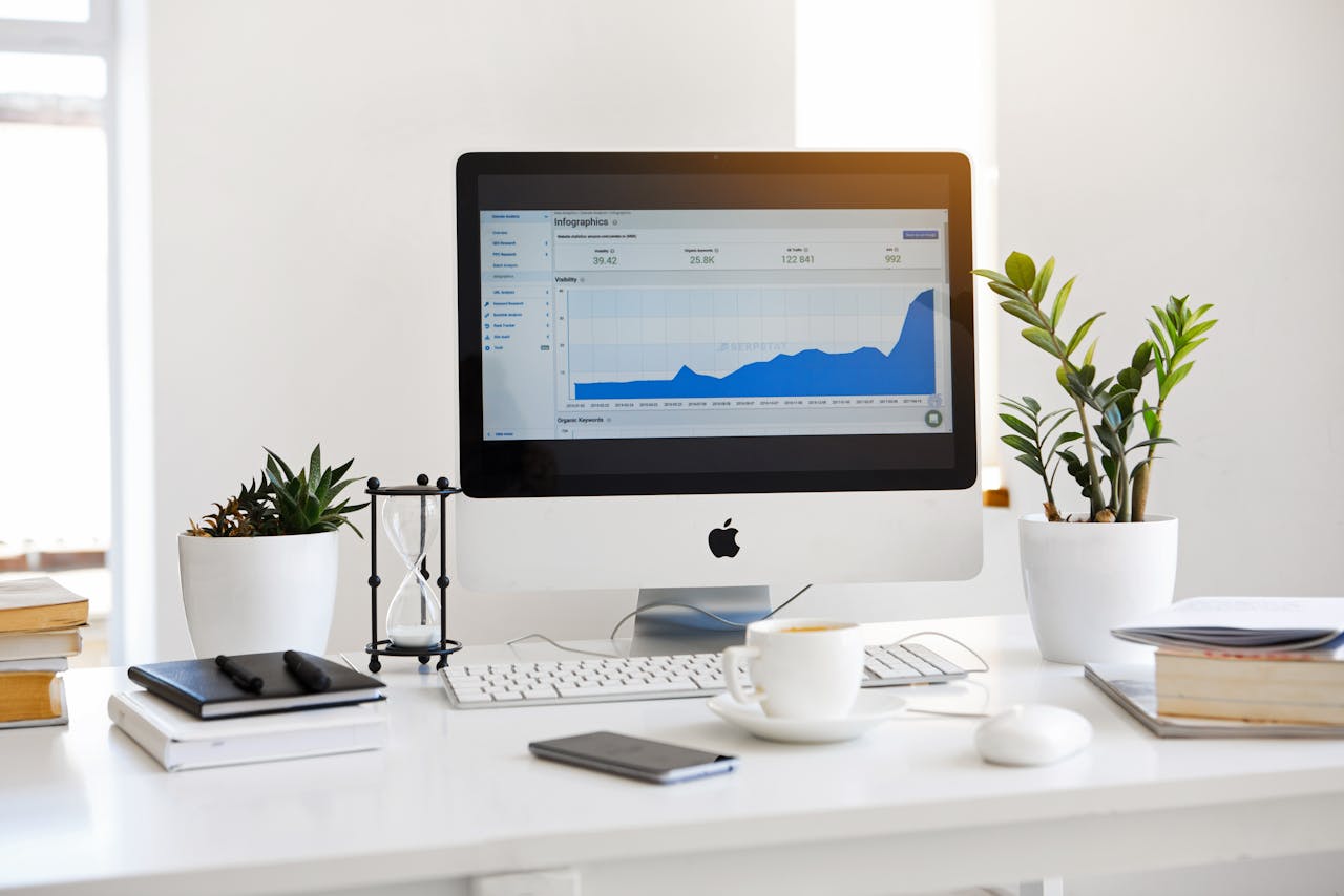 about-img-01 A clean, contemporary workspace featuring a desktop with analytics on the screen and plants for a fresh look.